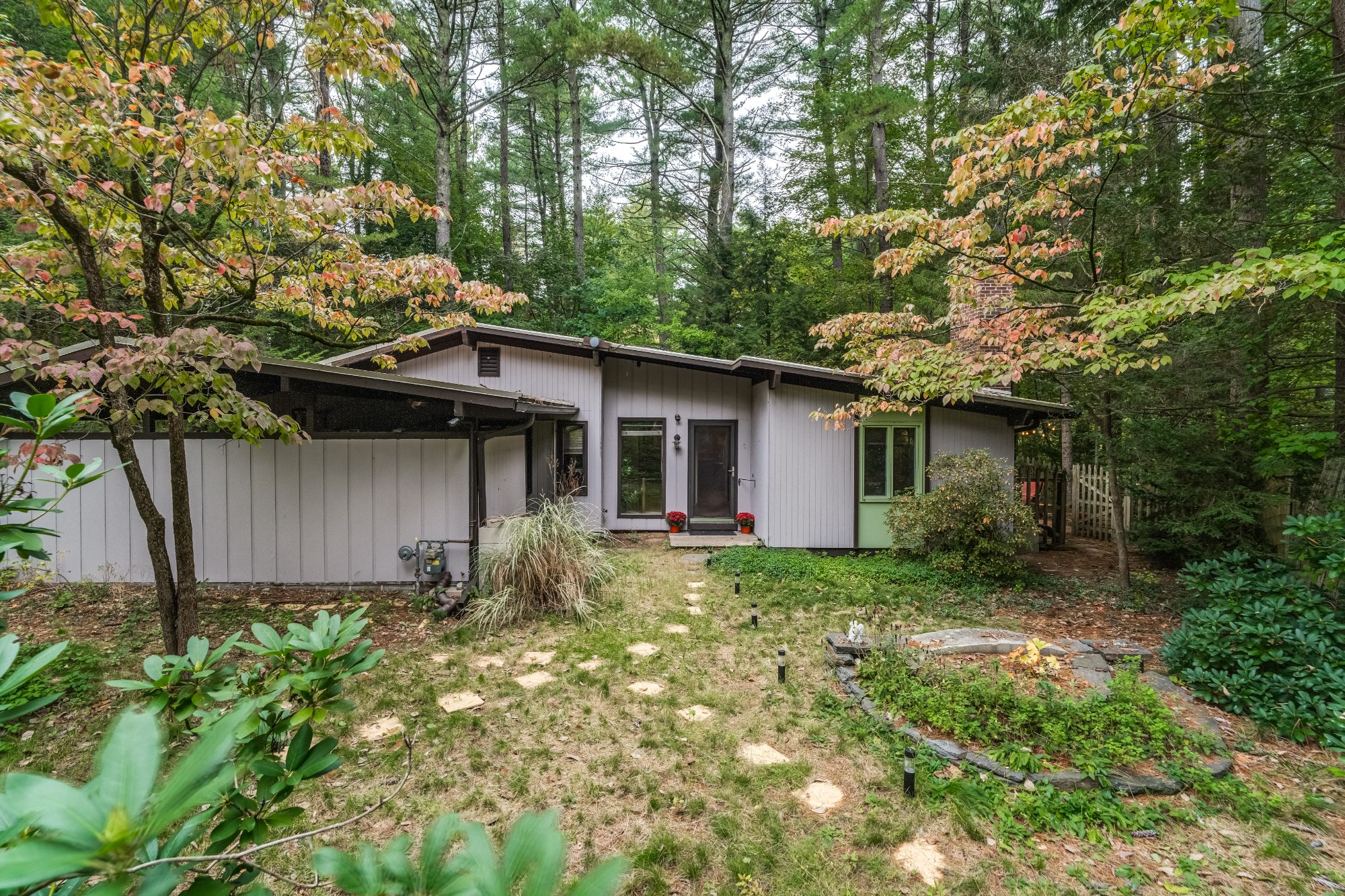 Mid-century ranch exterior among tall pines