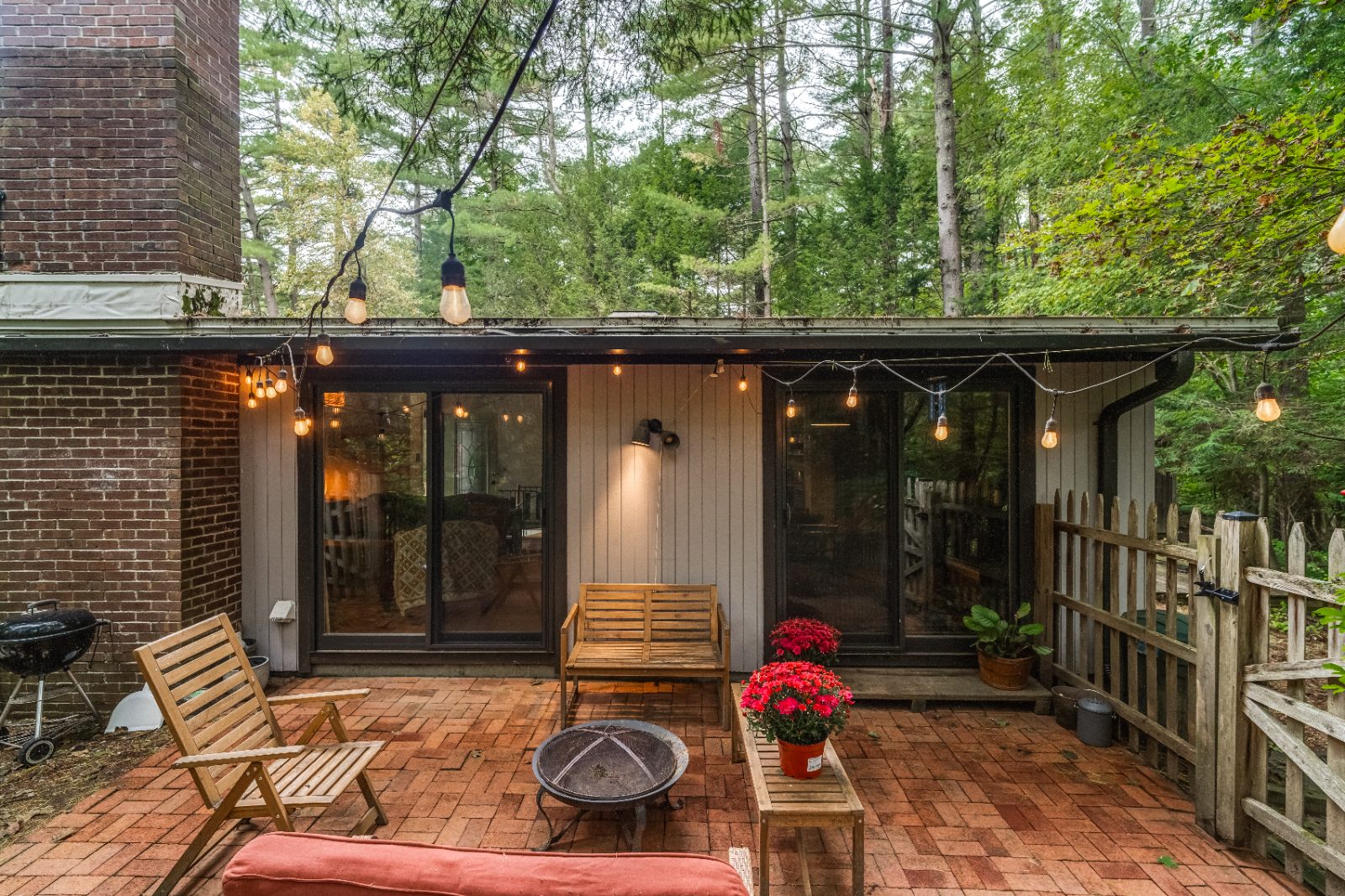 Brick patio with string lights off the living room sliders